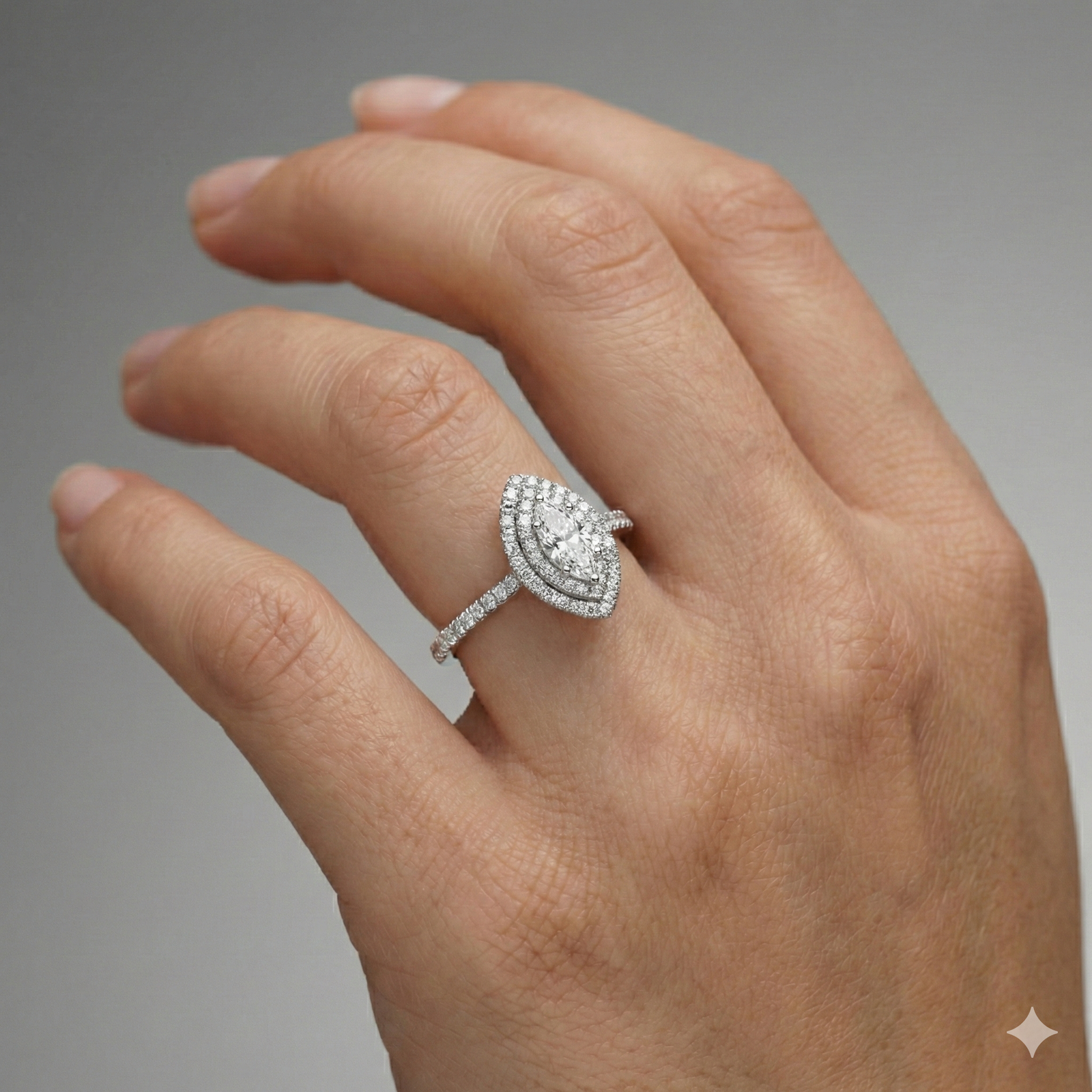 Marquise cut diamond engagement ring in 14k white gold with a prong diamond band and cathedral setting on a hand