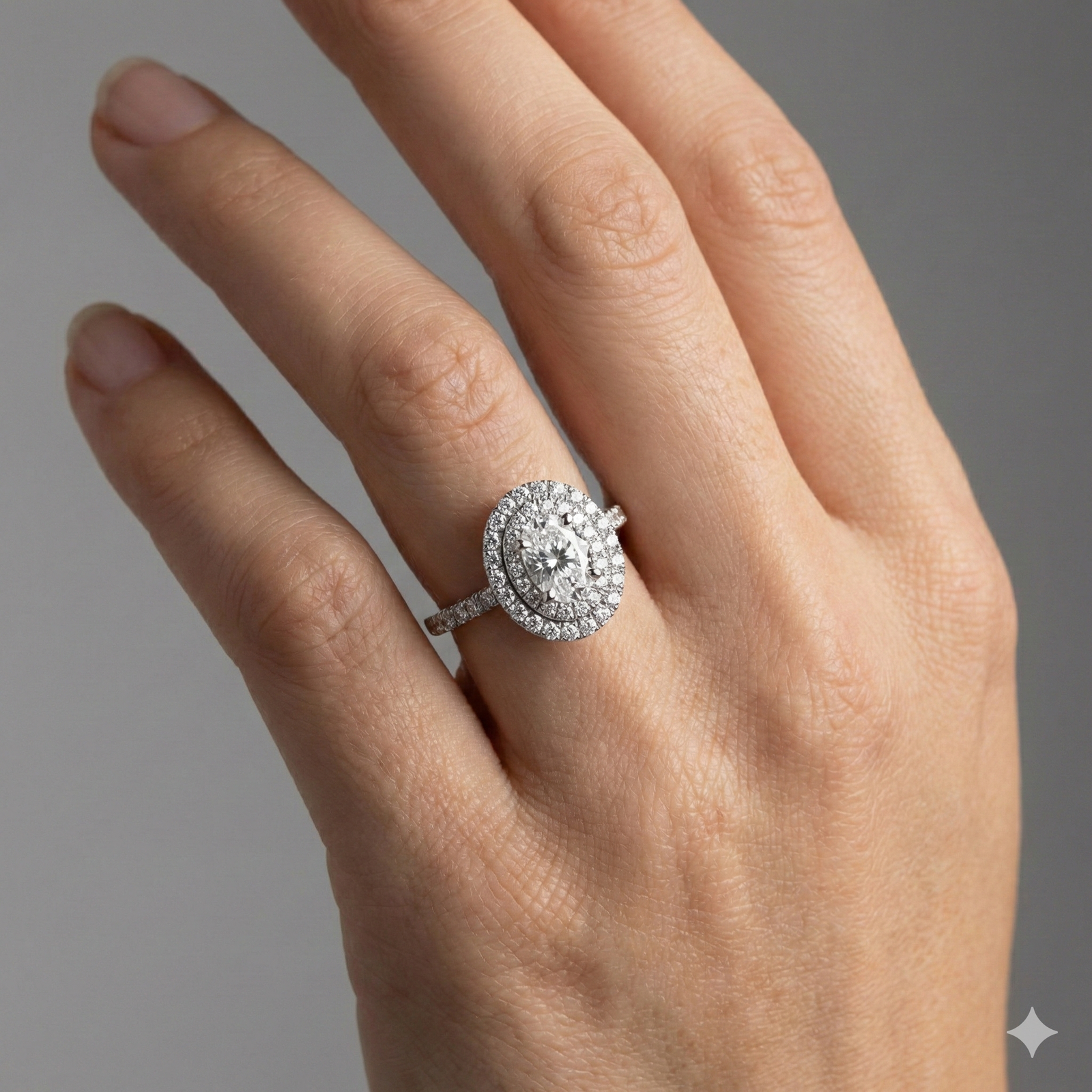 Oval cut diamond engagement ring in 14k white gold with a prong diamond band and cathedral setting on a hand