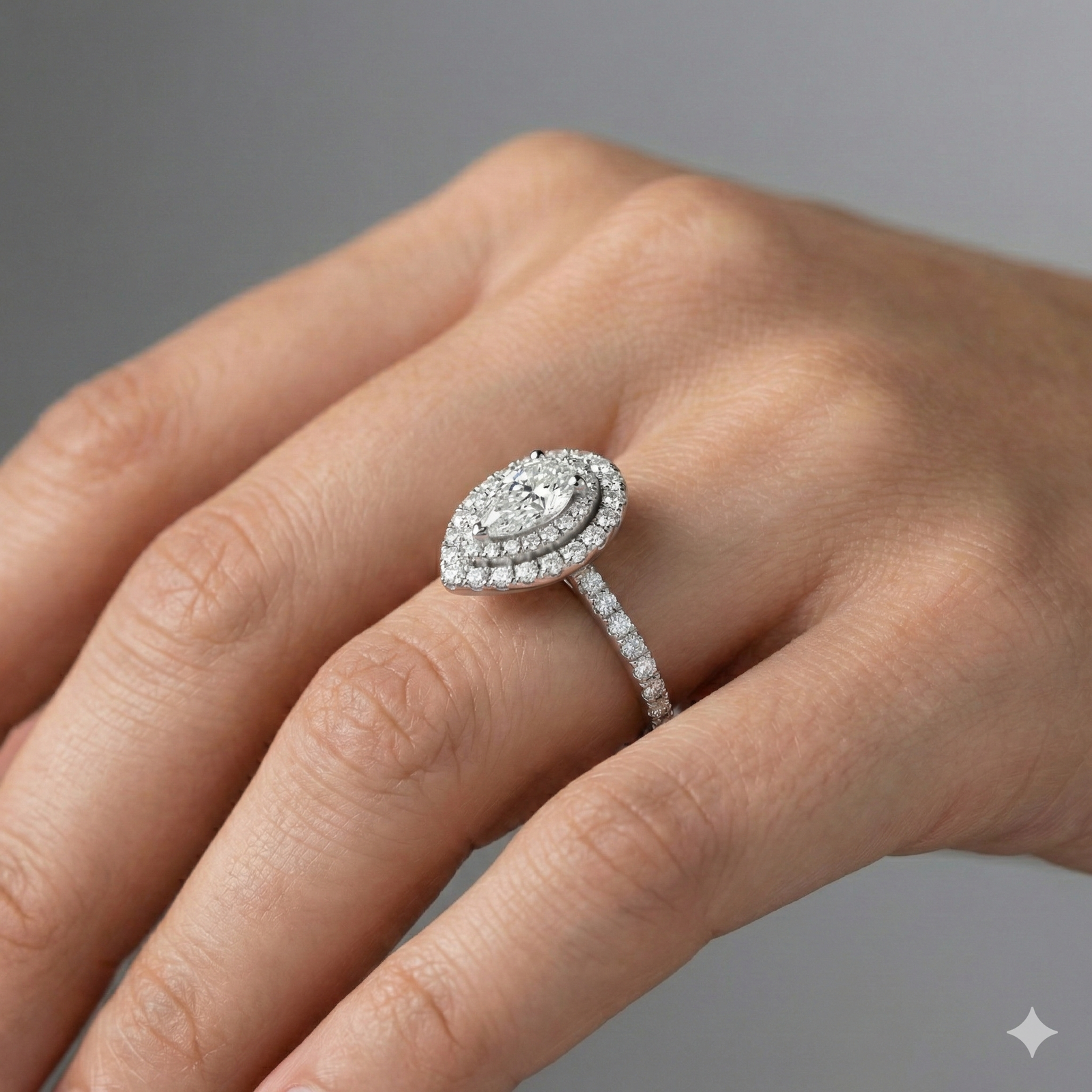 Pear cut diamond engagement ring in 14k white gold with a prong diamond band and cathedral setting on a hand
