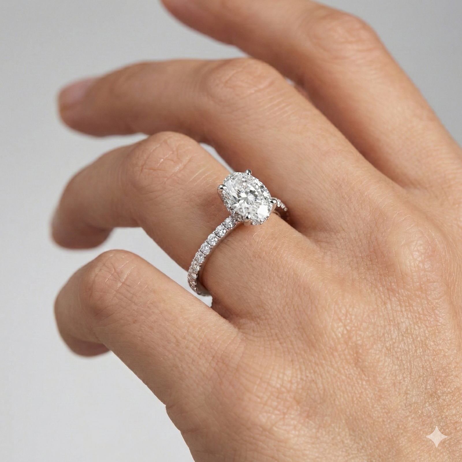 Oval cut diamond engagement ring in 14k white gold with a prong diamond band and cathedral setting on a hand