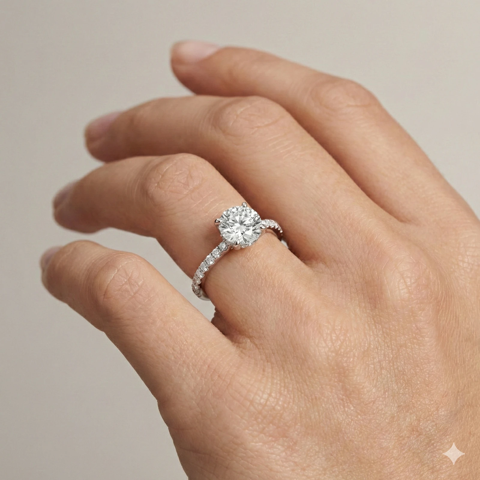 Round cut diamond engagement ring in 14k white gold with a prong diamond band and cathedral setting on a hand