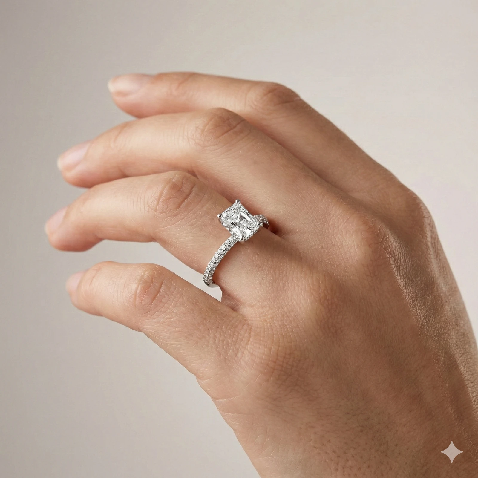 Radiant cut diamond engagement ring in 14k white gold with a pavé diamond band and cathedral setting on a hand