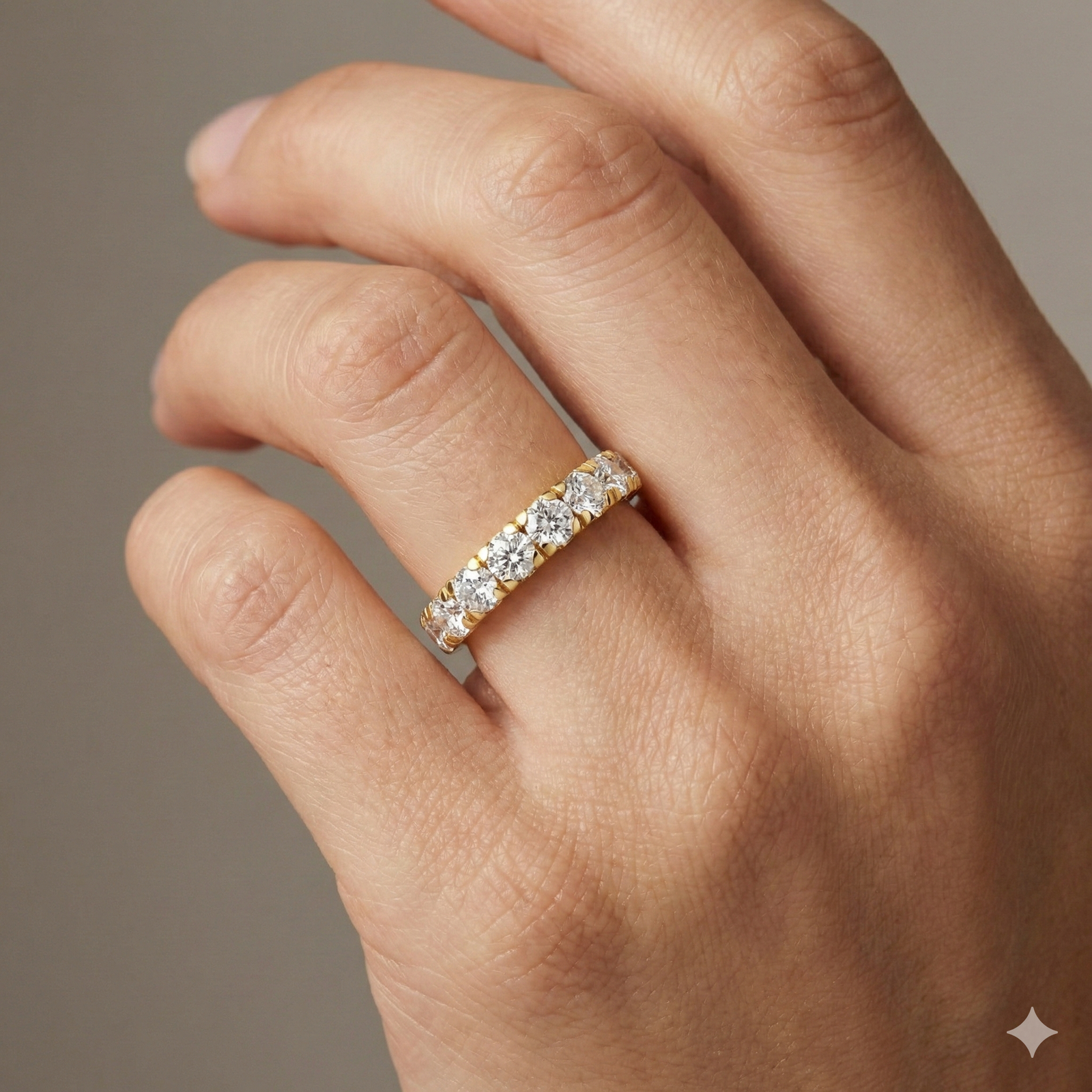 A sleek 14k yellow gold wedding band featuring 1.5 total carats of round-cut lab-grown diamonds in a secure channel-set 2/3 eternity style on hand.