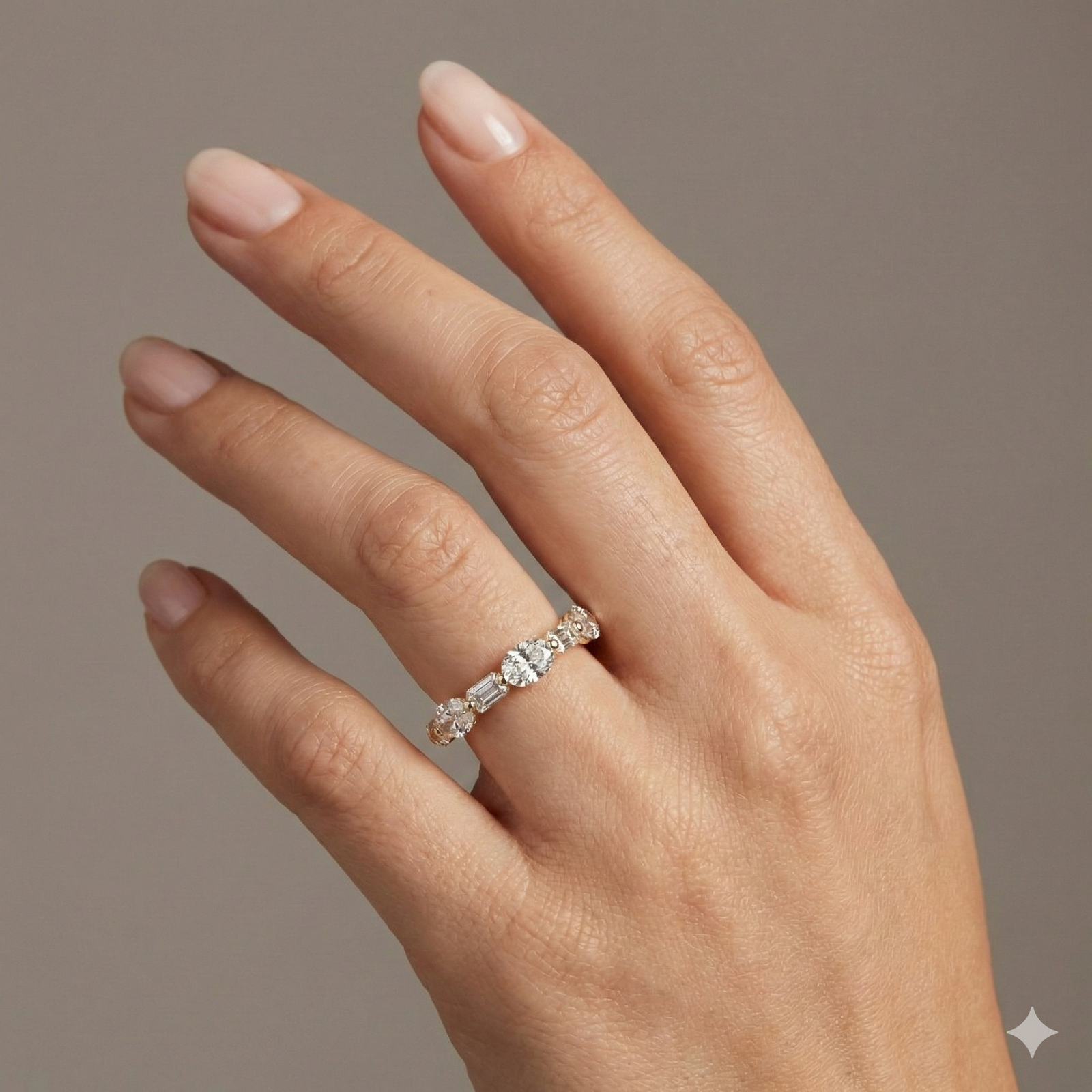 A unique 14k yellow gold wedding band featuring an alternating pattern of shimmering oval and crisp emerald-cut lab-grown diamonds totaling 1.6 carats on hand.