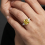 Lifestyle view of a white gold ring worn on the hand, showcasing a yellow diamond center with white diamond side stones.