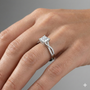 Princess cut diamond engagement ring in 14k white gold with a prong diamond band and twist setting on a hand