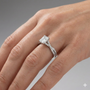 Radiant cut diamond engagement ring in 14k white gold with a prong diamond band and twist setting on a hand