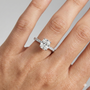 Elongated cushion cut diamond engagement ring in 14k white gold with a pavé diamond band and cathedral setting on a hand