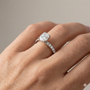 Elongated cushion cut diamond engagement ring in 14k white gold with a prong diamond band and cathedral setting on a hand