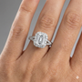 Emerald cut diamond engagement ring in 14k white gold with a diamond channel band and split setting on a hand