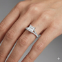 Princess cut diamond engagement ring in 14k white gold with a diamond channel band and split setting on a hand