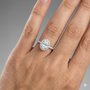 Oval cut diamond engagement ring in 14k white gold with a prong diamond band and cathedral setting on a hand