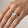 Emerald cut diamond engagement ring in 14k white gold with a pavé diamond band and solitaire setting on a hand
