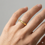 A high-polish 14k yellow gold geometric stackable ring by Amorati, featuring a unique multi-angled design. Amorati’s signature F O U R T E E N T H Collection on hand.