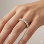A luxurious 14k yellow gold full eternity band featuring 2.0 total carats of round-cut lab-grown diamonds set in unique, sculptural twist prongs on hand.