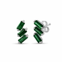 A pair of cascading stud earrings featuring a vertical arrangement of three baguette-cut emeralds in a deep, saturated green. The rectangular gemstones are staggered in a step-like formation and held in a minimalist 18k yellow gold setting, shown against a clean, white studio background.
