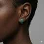 A close-up, profile shot of a person’s ear and jawline, showcasing the Cascading Baguette-Cut Stud Earrings. The model’s hair is swept back, allowing the jewelry to take center stage against a soft-focus, neutral background.