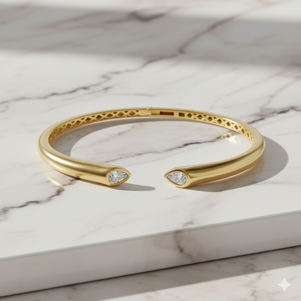 A lifestyle image  view of a 14K yellow gold open cuff bracelet, showing a brilliant bezel-set diamond at one end.