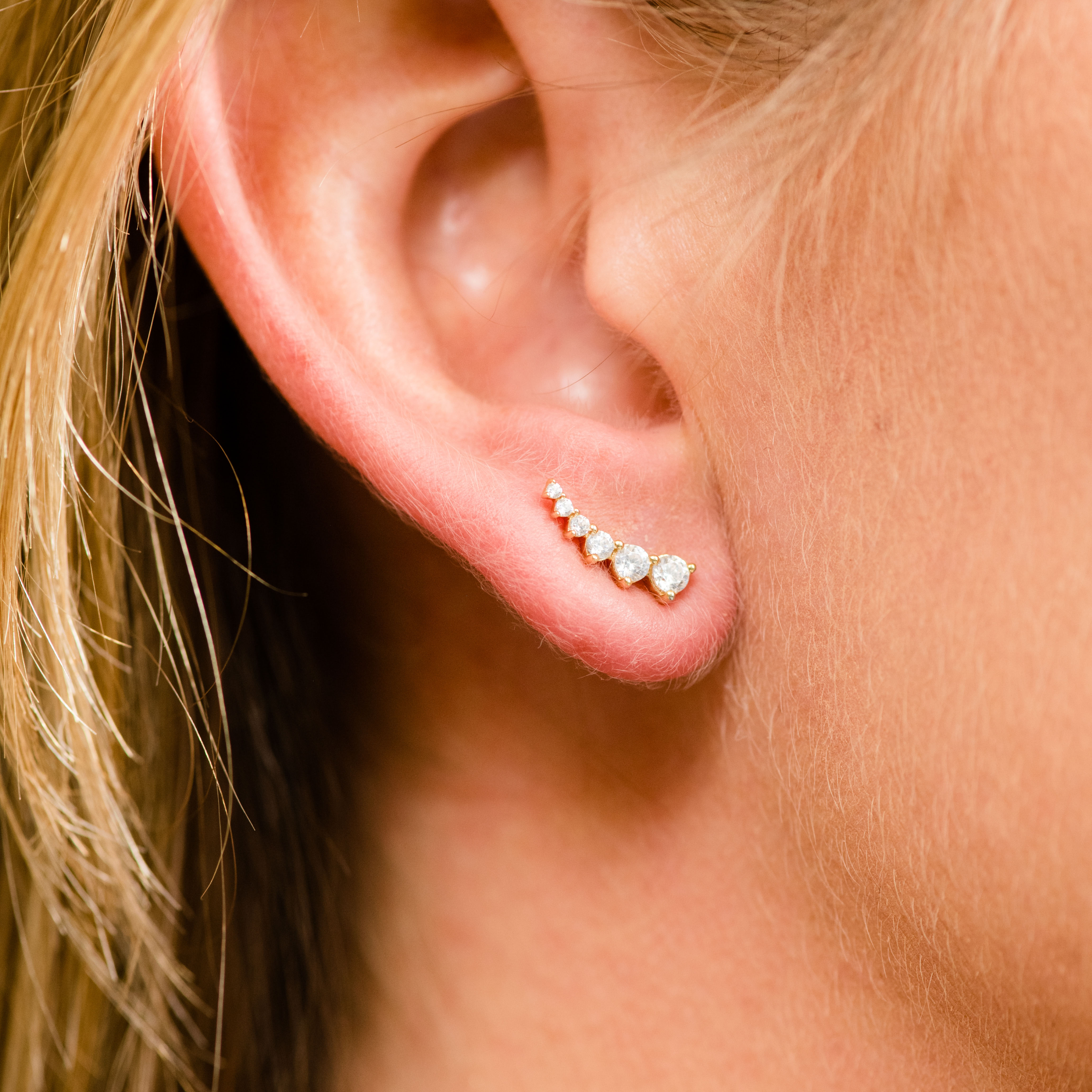 Amorati Diamonds 14K white gold delicate diamond climber earring with a line of graduated pavé diamonds, shown on a model.