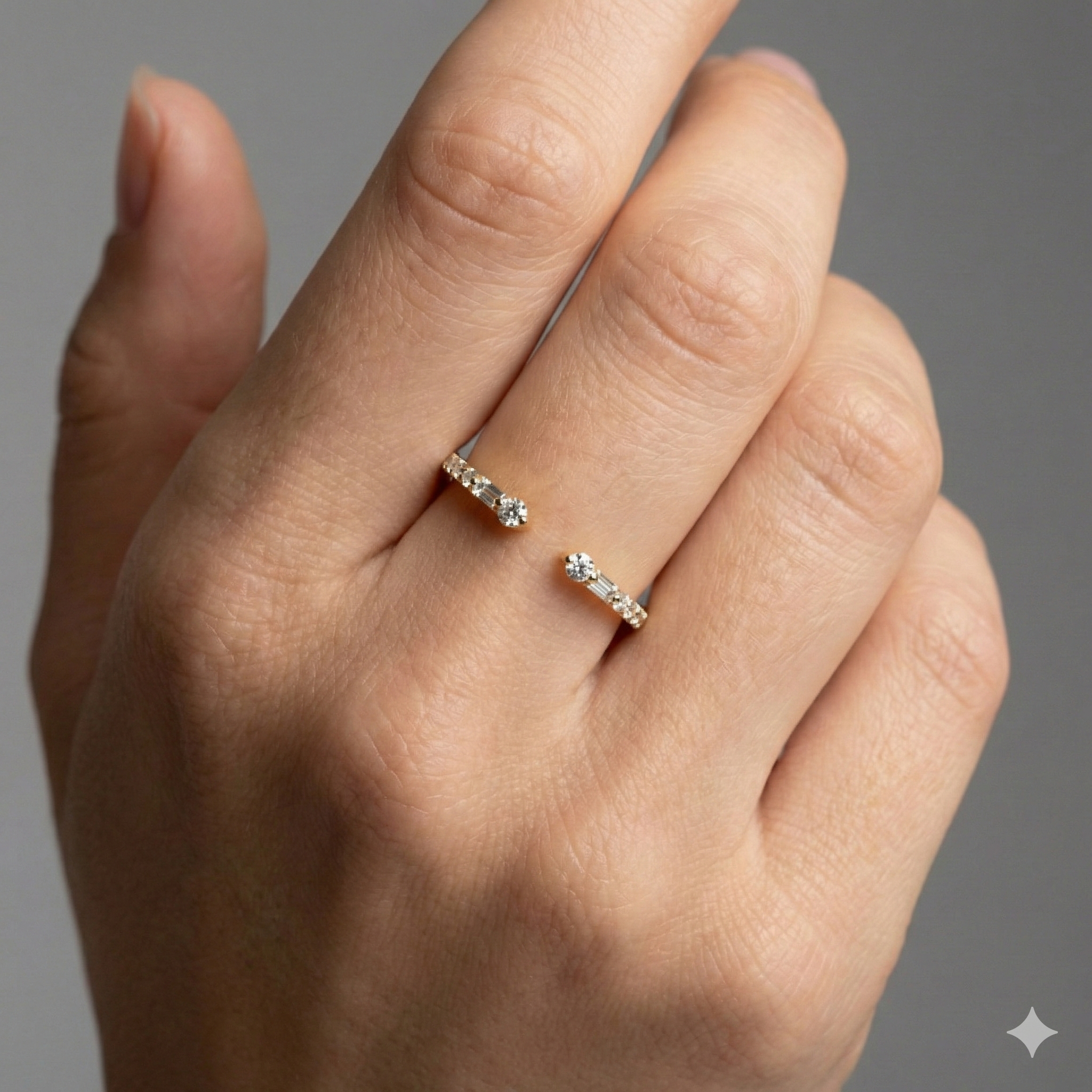 Amorati Diamonds Embrace Cluster Ring, a top-down view of a 10K yellow gold bypass ring with a three-diamond cluster at each end on hand.
