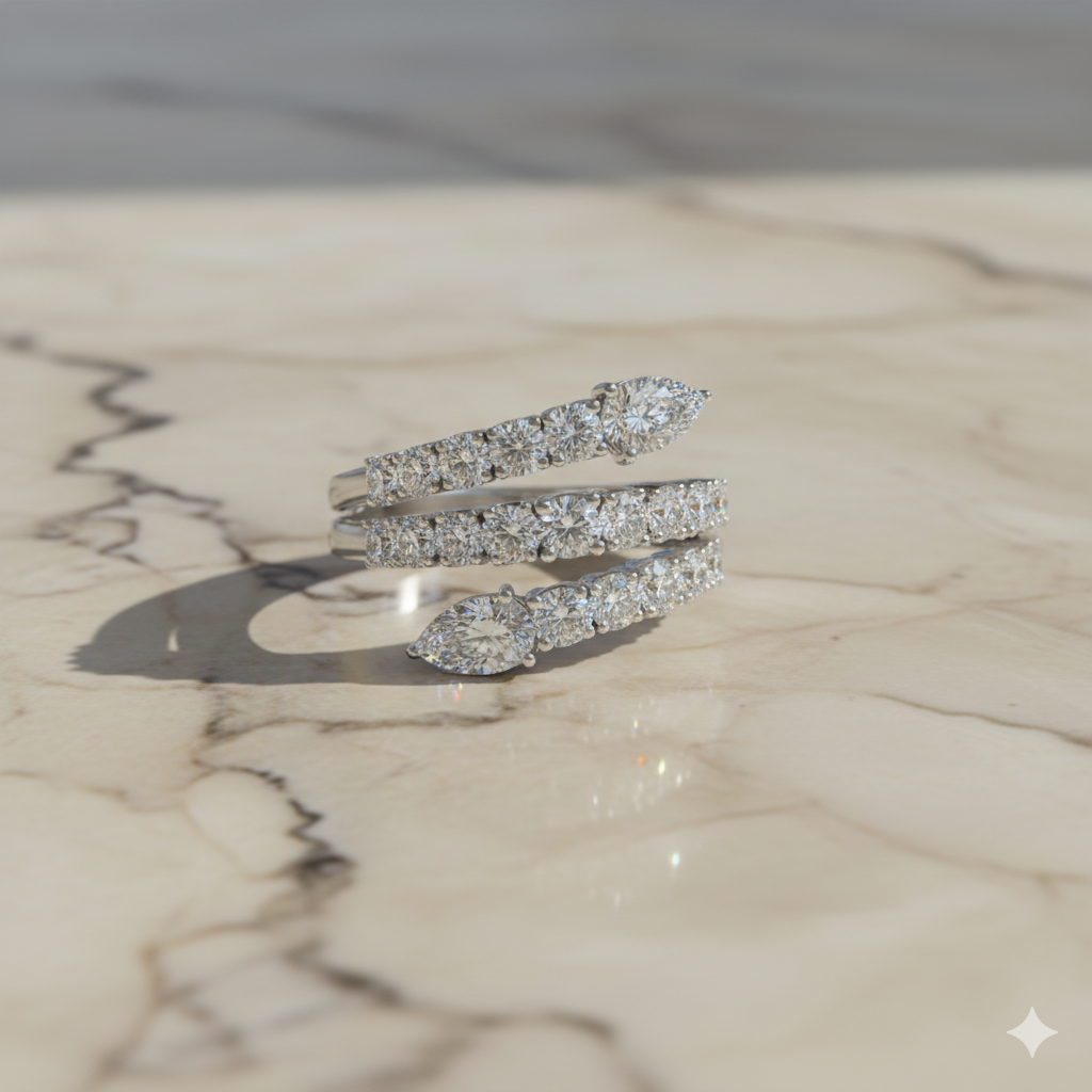 A top-down view of a 14K white gold open-shank ring with a continuous spiral design and a pavé diamond surface set atop marble.