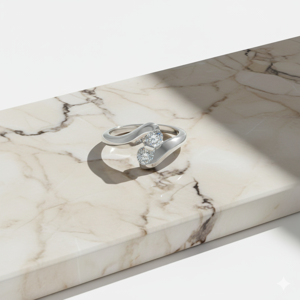 A close up view of a 14K white gold bypass ring featuring two brilliant-cut diamonds set side-by-side, set on a marbled display block.