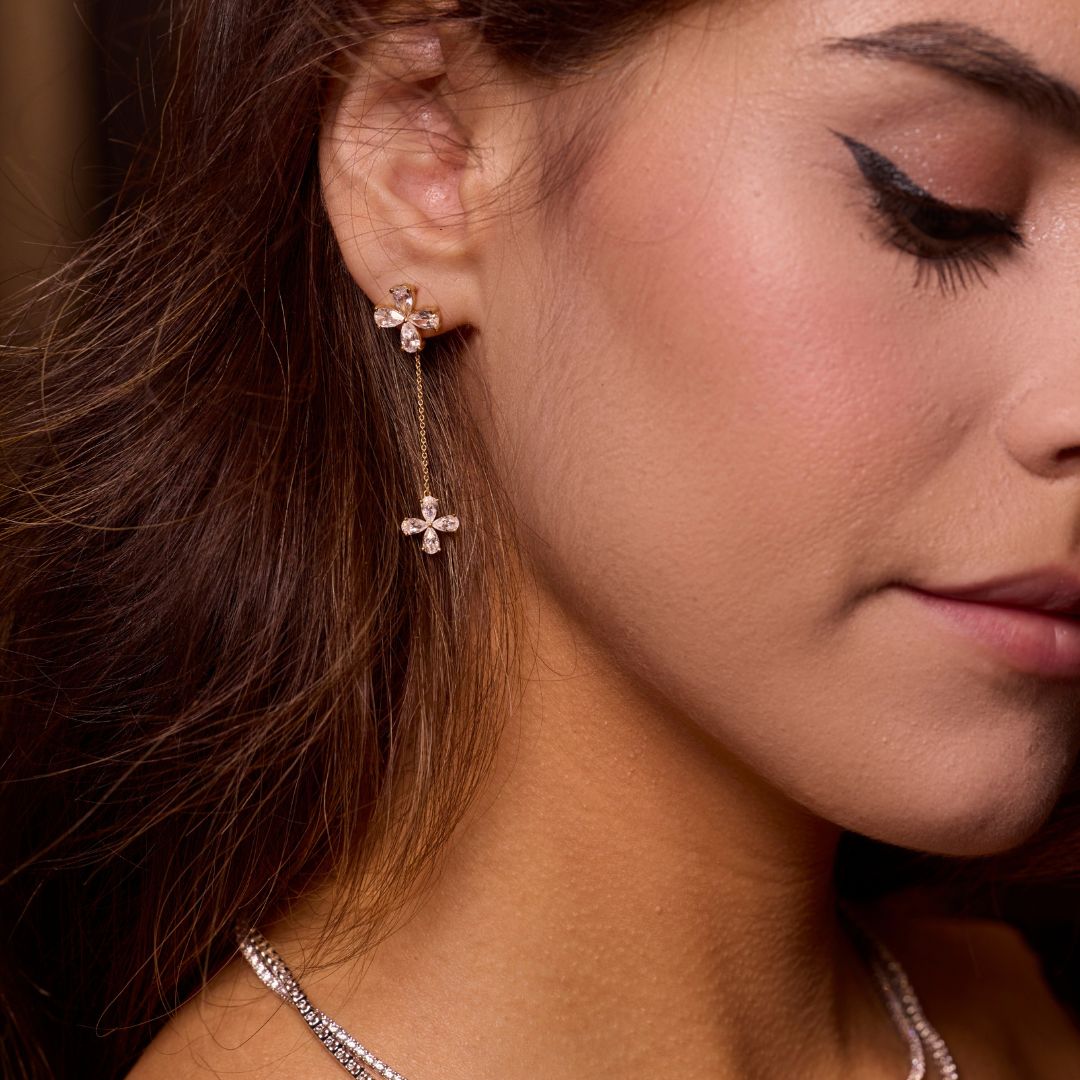 White gold floral diamond drop earrings worn on ear, showing graceful movement, balanced proportions, and feminine sparkle.