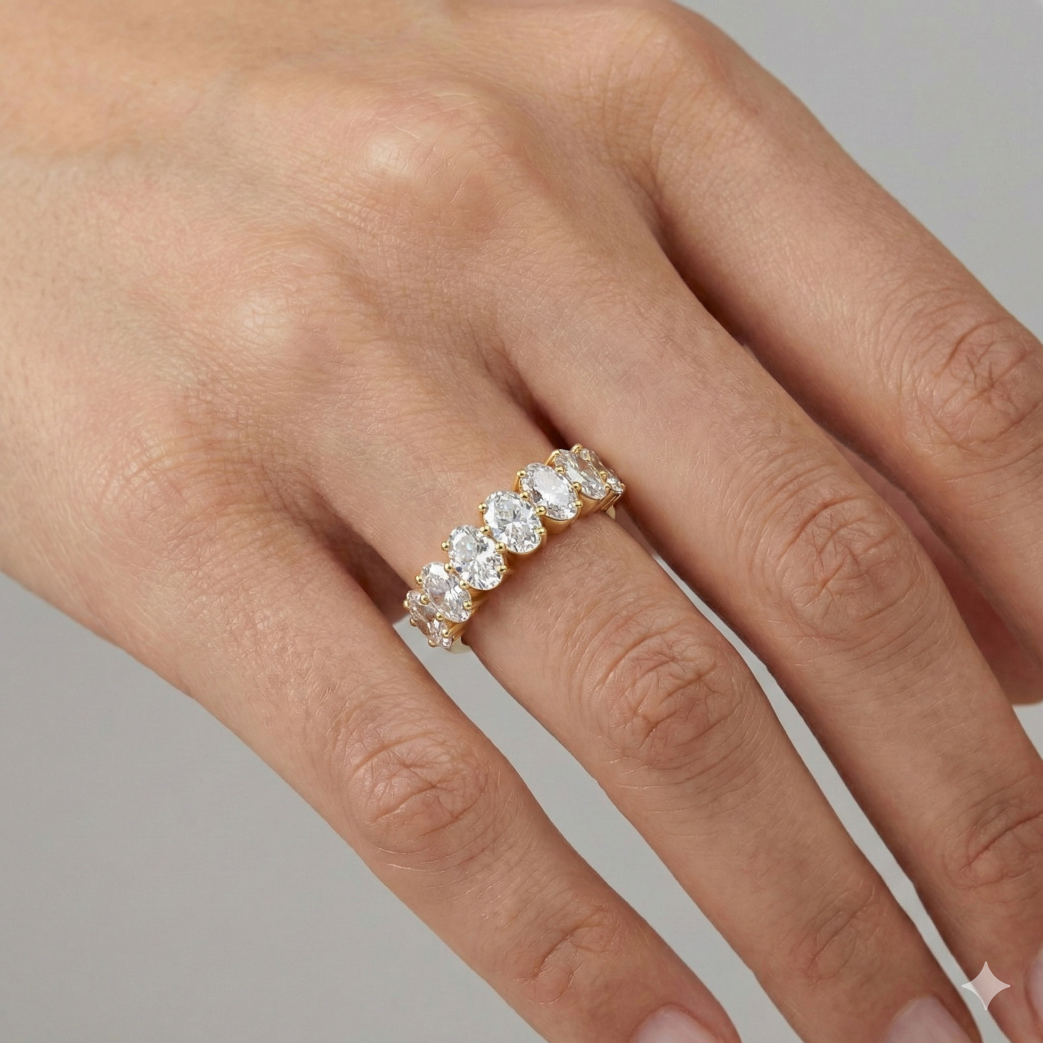 A luxurious 14k yellow gold 2/3 eternity wedding band featuring 1.0 total carat of graduated oval-cut lab-grown diamonds on the figure.