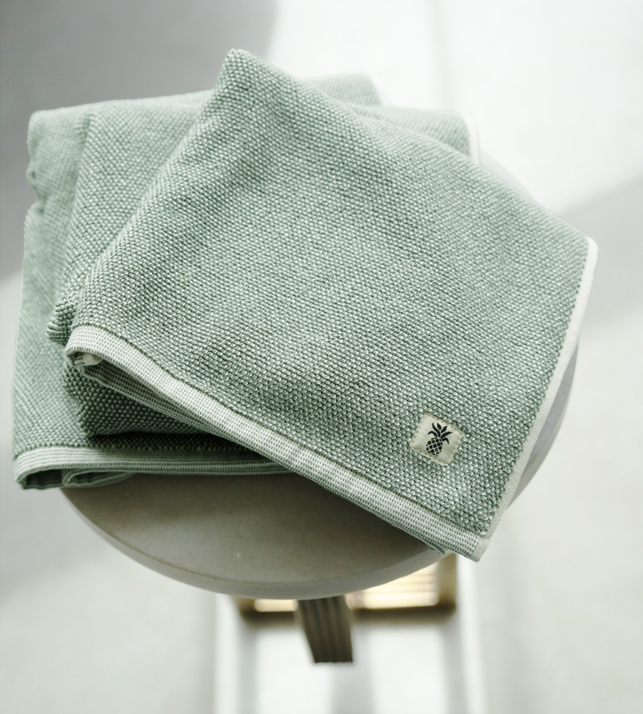 stack of two tone bath sheets on a wood stool