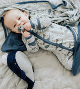 baby laying on hush gray quilt