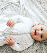 baby laying on dot receiving blanket