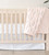 wildflowers petal pink quilt hanging on side of crib