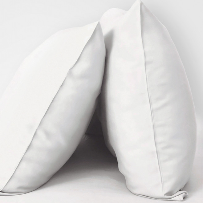 2 pillows with White resort pillowcases on them