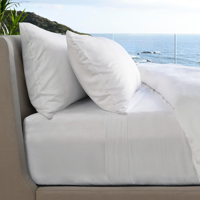 side view of bed made with white resort sheets