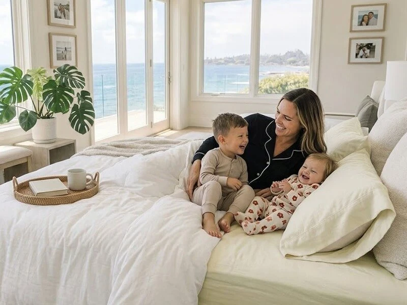 A luxuriously made bed with bamboo sheets and a mother and her kids