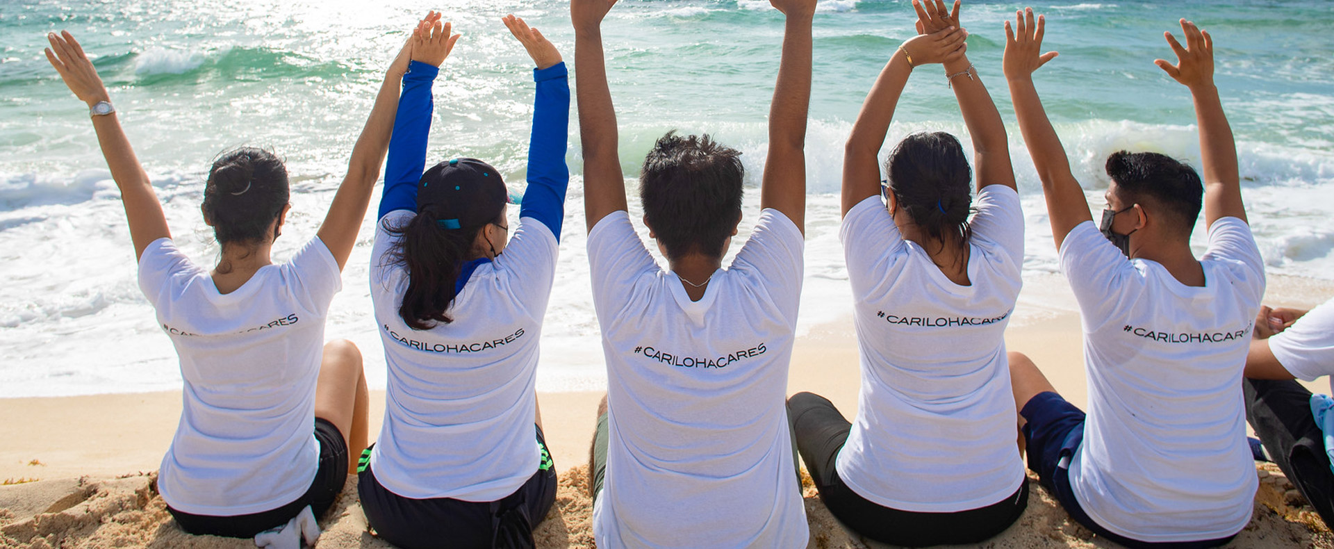 cariloha employees on the beach wearing cariloha cares t-shirts