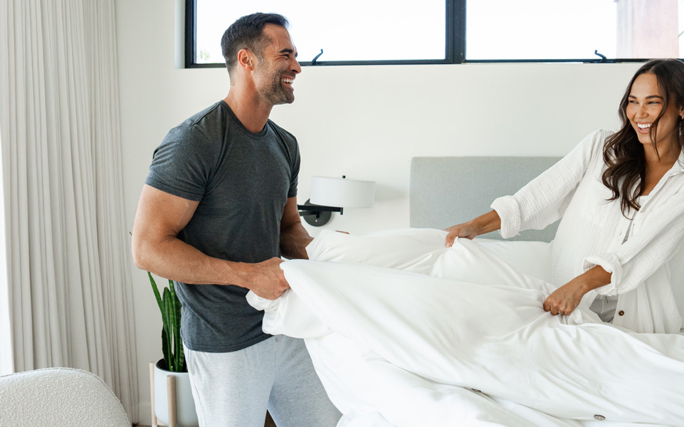 man and women lying on a bed wearing cariloha sleepwear