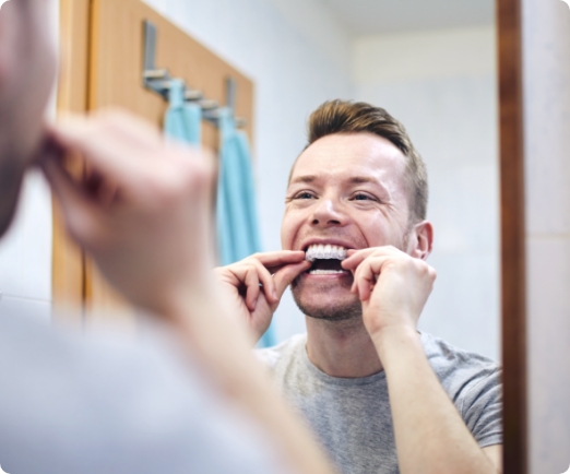 Man using teeth whitening trays