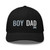 Black six-panel mesh-back trucker cap with embroidered Boy DAD logo, front view — DAD all caps