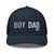 Navy six-panel mesh-back trucker cap with embroidered Boy DAD logo, front view — DAD all caps