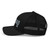 Black six-panel mesh-back trucker cap with embroidered OG DAD logo, left side view — DAD all caps