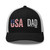 Black/White six-panel mesh-back trucker cap with embroidered USA DAD logo, front view — DAD all caps