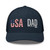 Navy six-panel mesh-back trucker cap with embroidered USA DAD logo, front view — DAD all caps