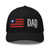 Black six-panel mesh-back trucker cap with embroidered Flag DAD logo, front view — DAD all caps