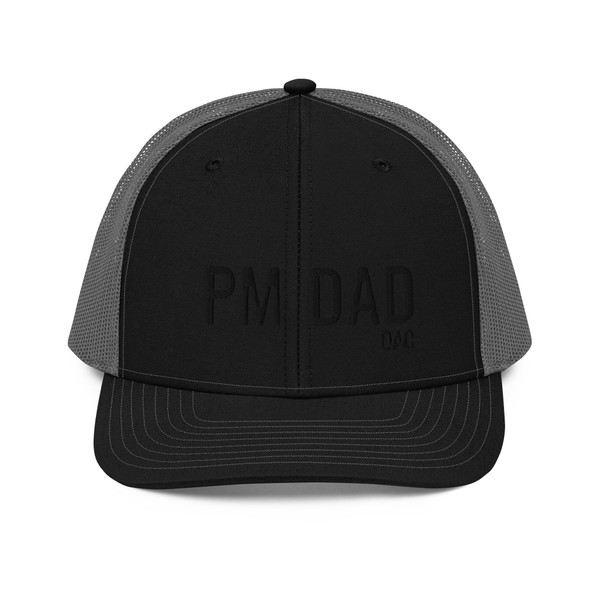 Black/Charcoal six-panel snapback-style trucker cap with embroidered Night Owl DAD logo, front view — DAD all caps