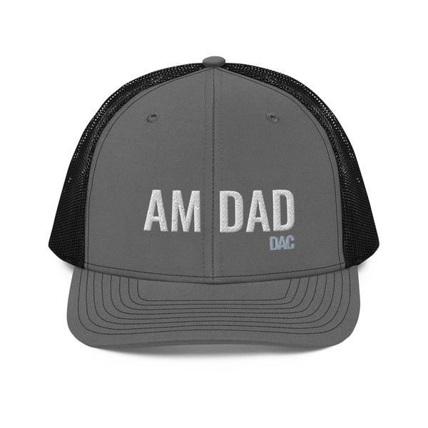 Charcoal/Black six-panel snapback-style trucker cap with embroidered Morning DAD logo, front view — DAD all caps