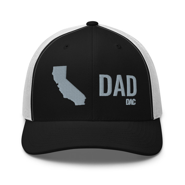 Black/White six-panel mesh-back trucker cap with embroidered Cali DAD logo, front view — DAD all caps