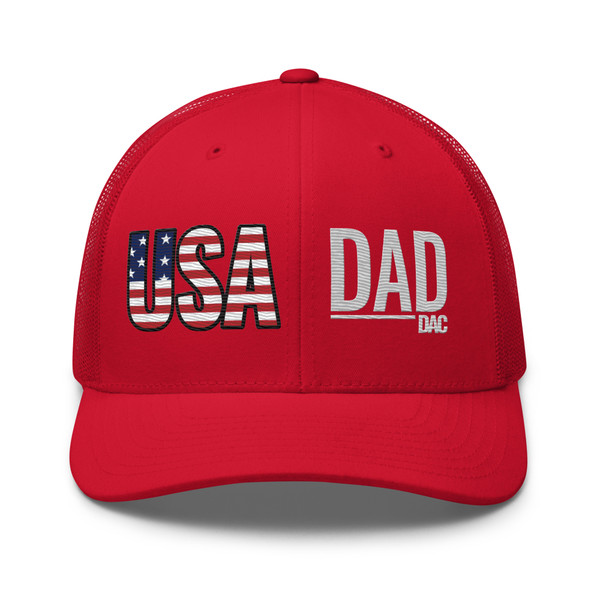 Red six-panel mesh-back trucker cap with embroidered USA DAD logo, front view — DAD all caps