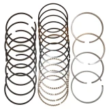 Assorted dark, silver, and corrugated piston rings arranged in groups on a white background. Piston ring set for 4-cylinder Allis-Chalmers farm tractors, including D17, WC, WD, WD45, WF, 170, and 175.
