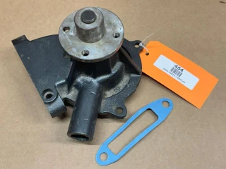 Water Pump for Allis-Chalmers 7030 - 8070, display view of a used water pump with attached blue gasket on a brown surface.